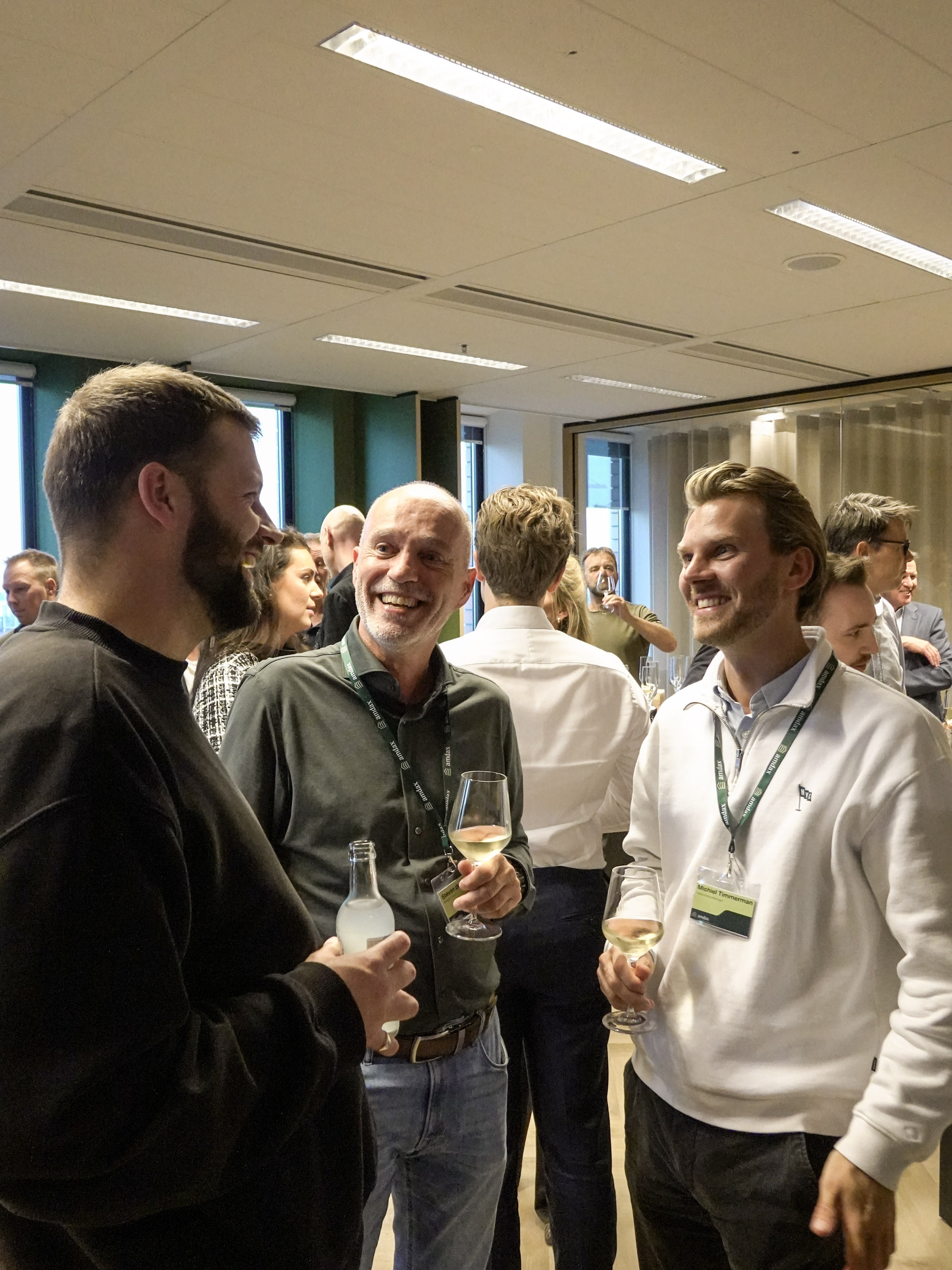 Guests chatting with drinks at a networking event in an office