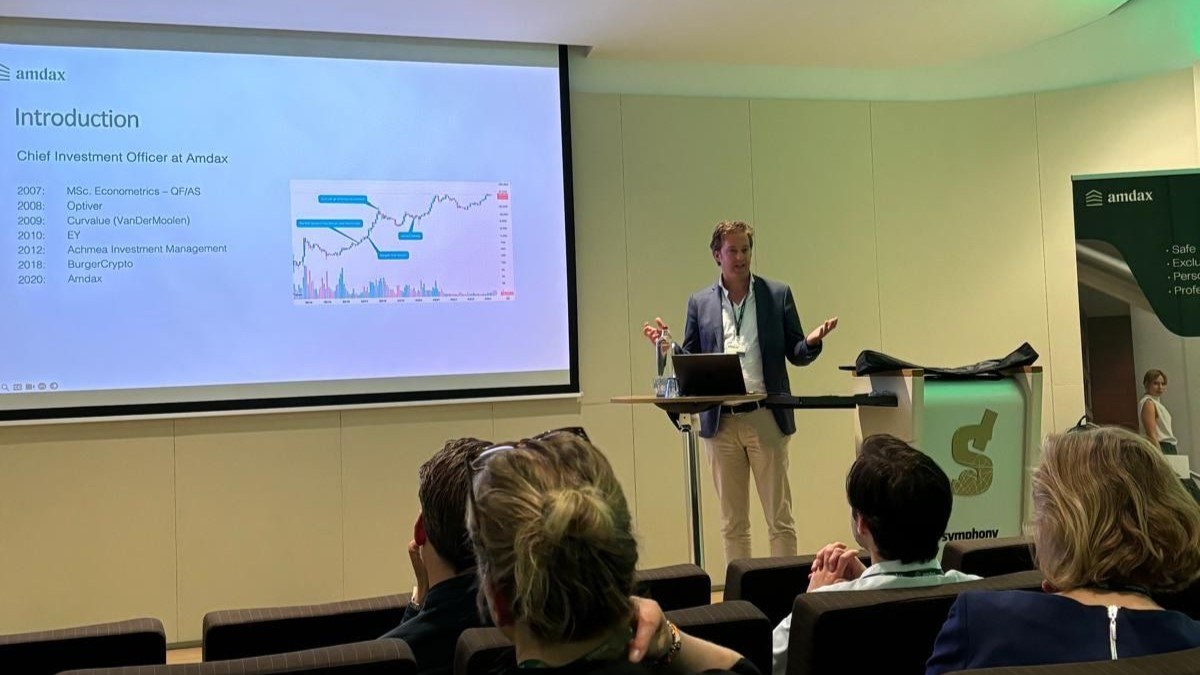 Chief Investment Officer van Amdax geeft een presentatie met een introductieslide voor een publiek